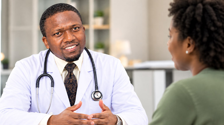 Dr. Solomon Kimera speaking with a patient